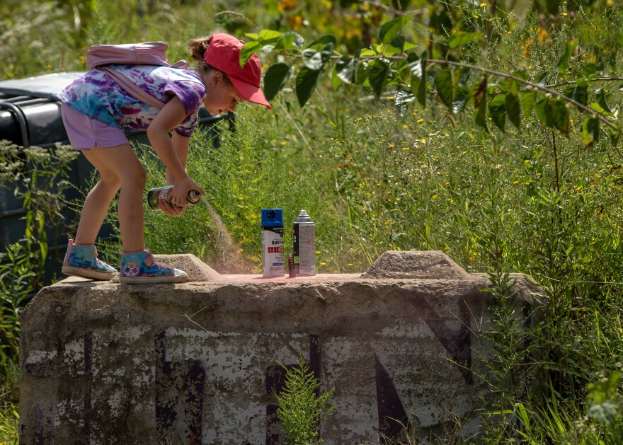 Starlit Love, 5, grafitties the top of a concrete block during “Paint Littles” on Sunday, Sept. 3, 2023 at Paint St. Louis 2023 in downtown St. Louis. “This is her first time doing this,” Love’s mother Jessica Schaible said. “This is awesome. She loves art.”