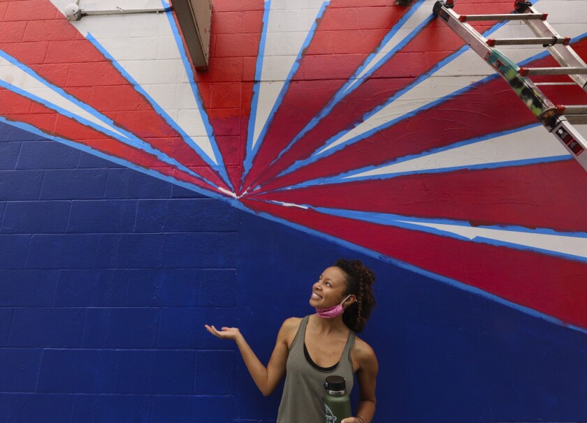 Artist Abi Mustapha poses with her mural on Cathcart Street in Santa Cruz