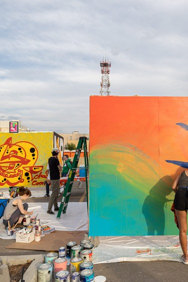Chad Coombs (left) and Brandi Hofer (right) paint their murals at the Urban Canvas Street Party