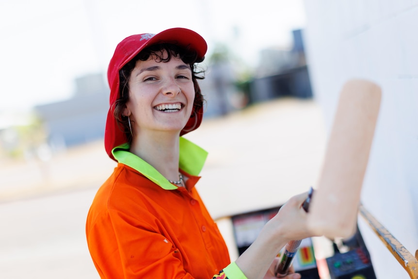 a portrait of a woman painting and smiling