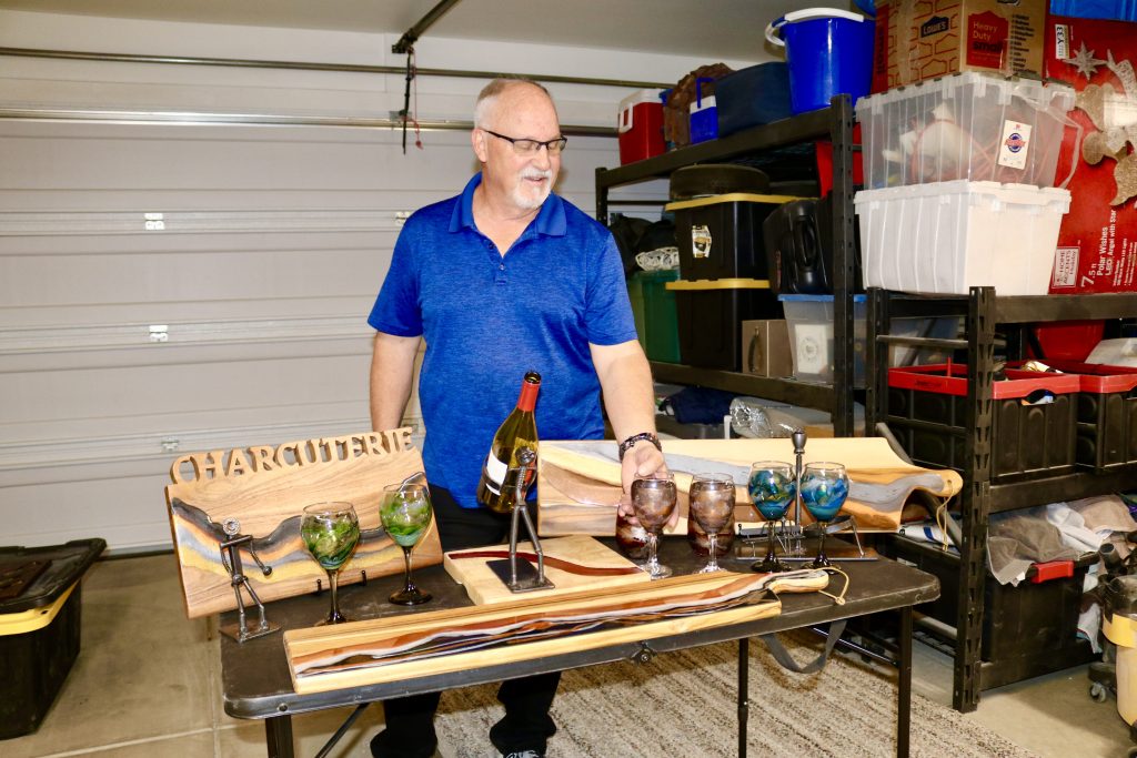 Kent Schlientz, owner of KC's Creations, sets up a table with his work inside his home garage in St. George, Utah, Aug. 22, 2023 | Photo by Jessi Bang, St. George News