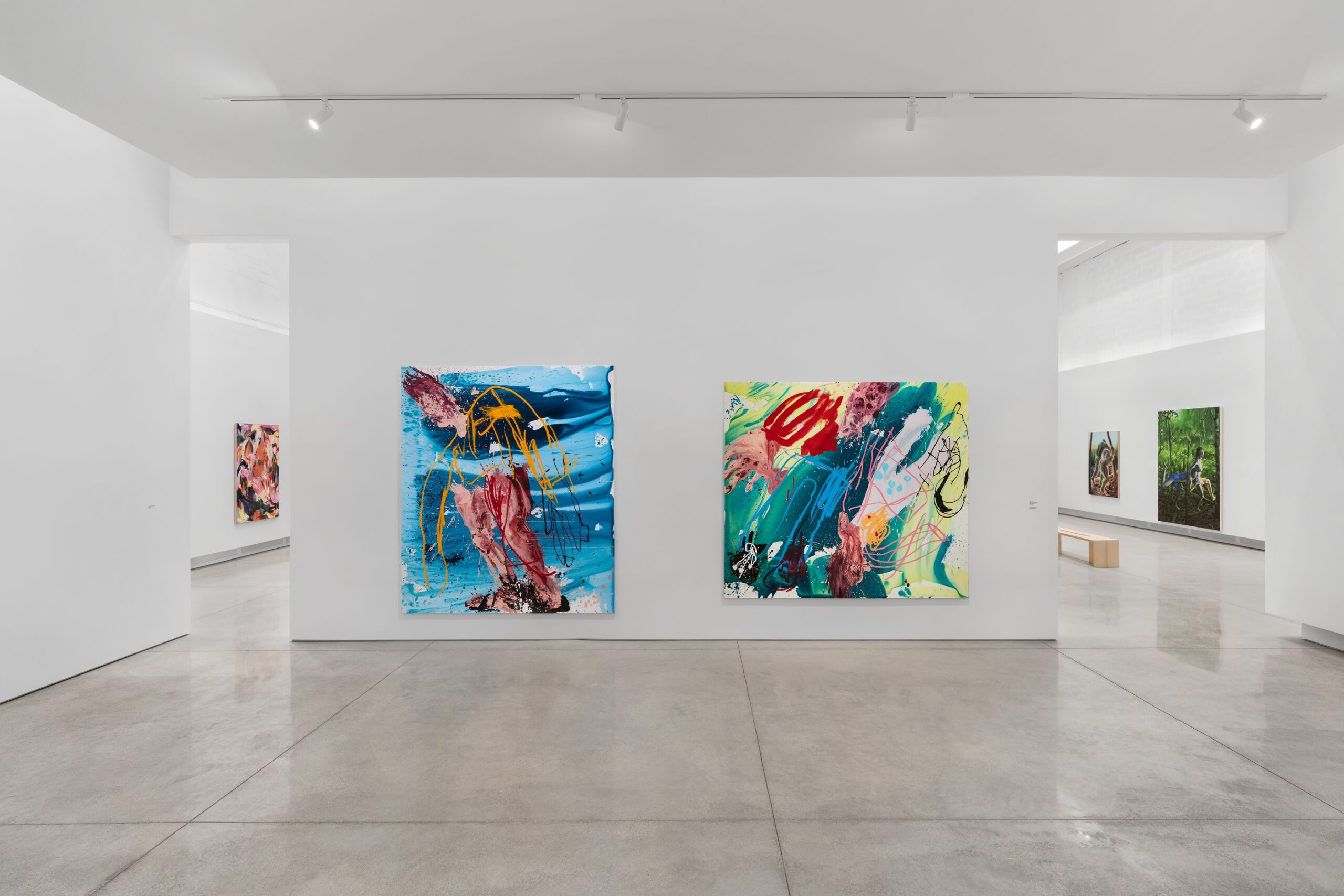 Two abstract paintings hanging on white gallery wall