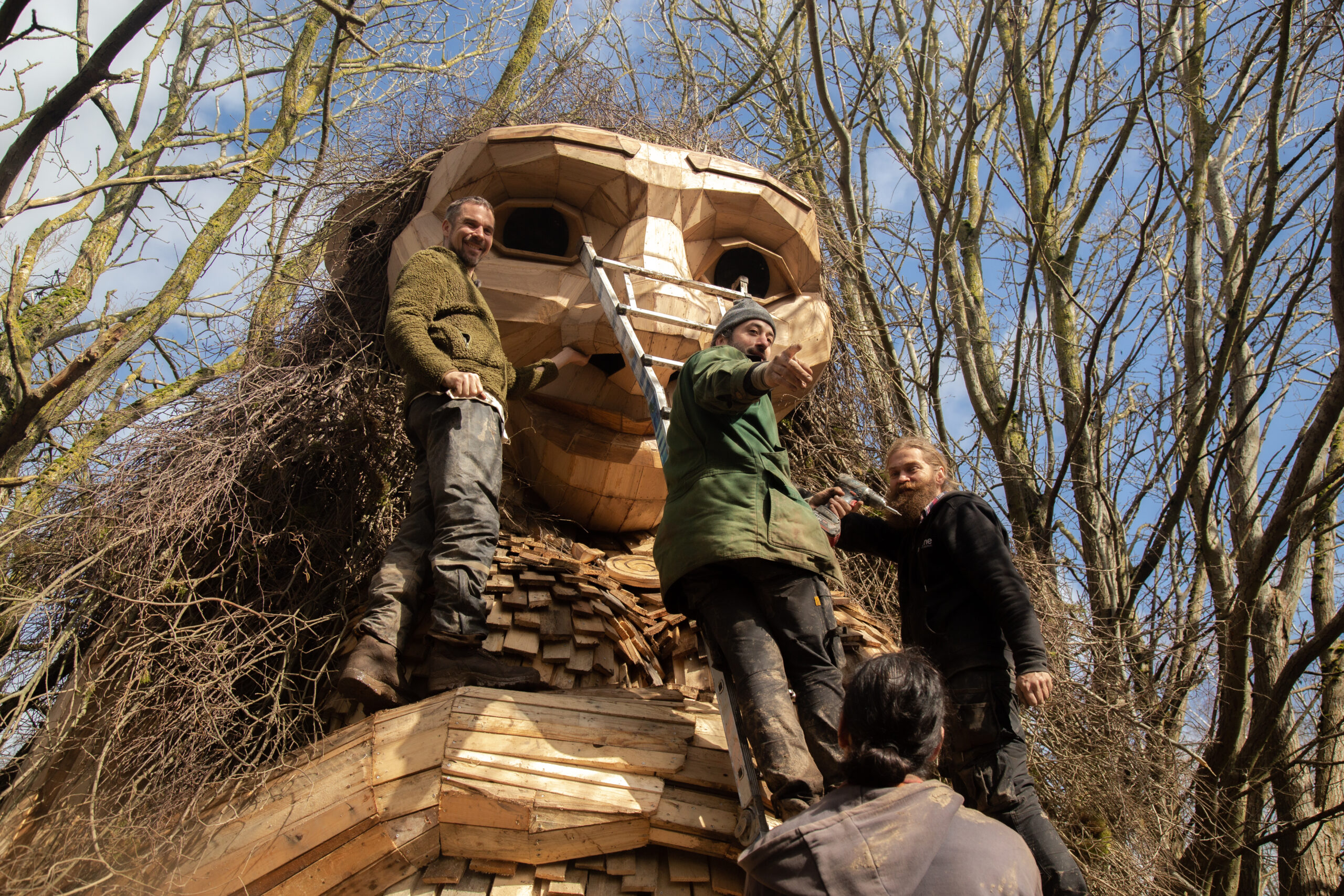 People work on building a giant wooden troll statue