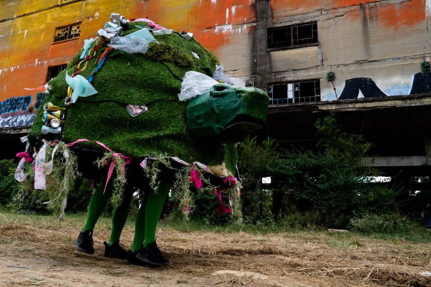 “The Trash Talking Turtle,” a moving art installation manned by Noah Laster and Mitchell Mainer struts along the Cotton Belt on Sunday, Oct. 8, 2023, during the Artica Urban Art Festival on the Mississippi Riverfront in downtown St. Louis.