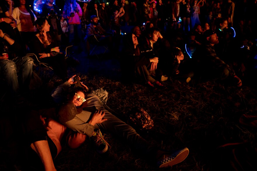 Robert Longer, 46, of south St. Louis, lays on Kristene Goodwin, 34, of downtown St. Louis, as they watch a wooden effigy burn on Sunday, Oct. 8, 2023, during the Artica Urban Art Festival along the Mississippi Riverfront.