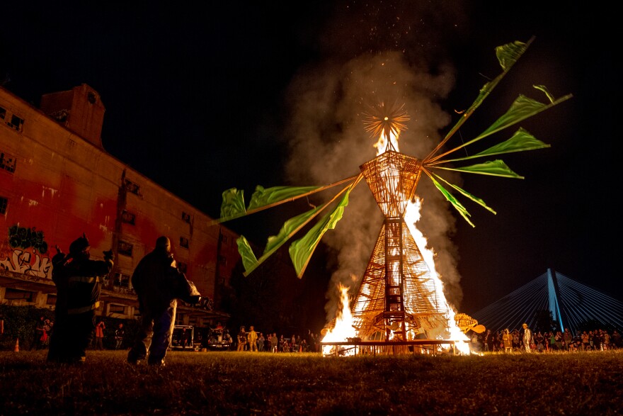 Firefighters watch as “Our Lady of Artica” burns on Sunday, Oct. 8, 2023, at the conclusion of the Artica Urban Art Festival on the Mississippi Riverfront in downtown St. Louis.