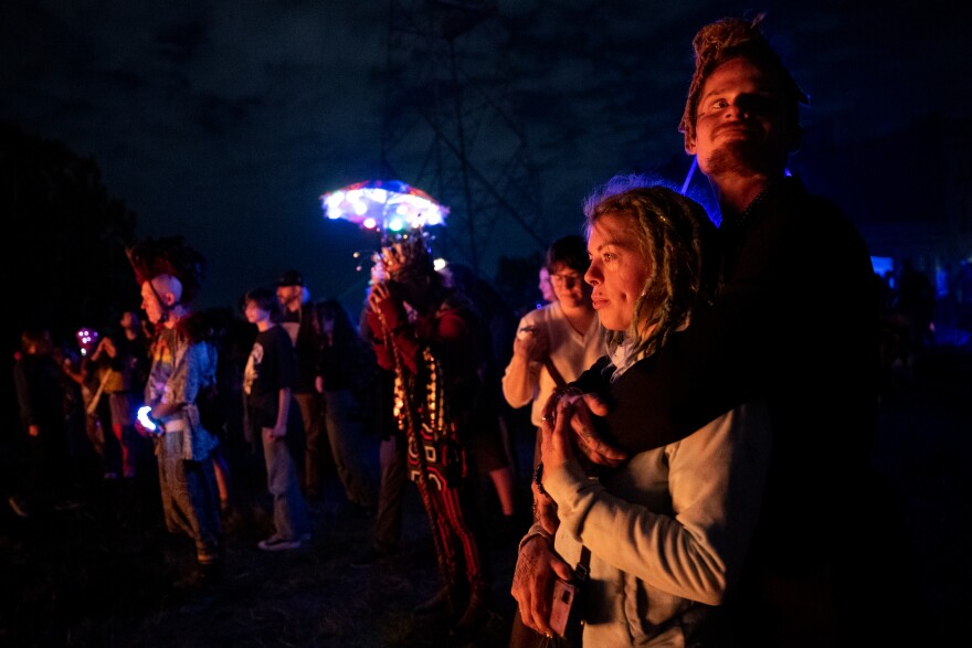 “Kiiing Dook,” a 34-year-old Florissant-based Hip Hop artist, embraces Brandie Foster, 29, of O’Fallon, Mo., as “Our Lady of Artica” burns on Sunday, Oct. 8, 2023, at the conclusion of the Artica Urban Art Festival in downtown St. Louis.