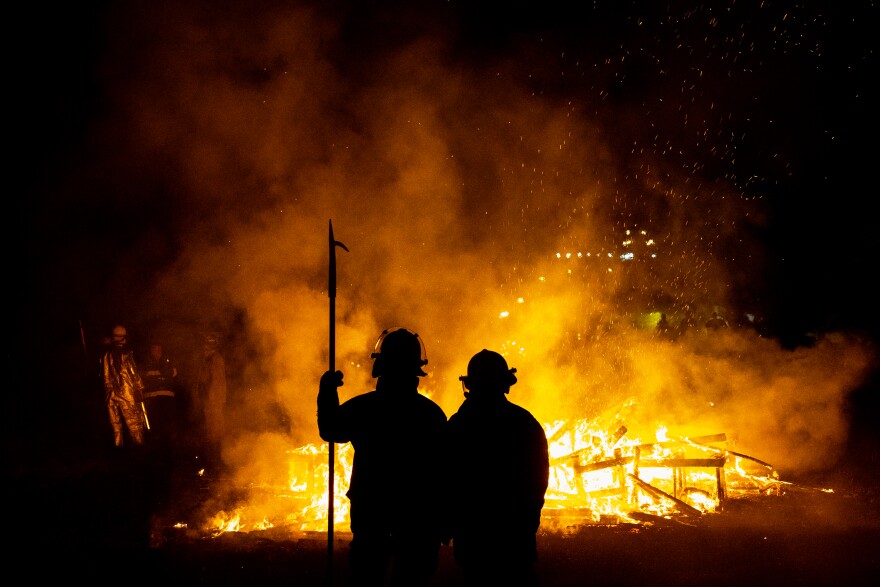 Firefighters watch as “Our Lady of Artica” burns on Sunday, Oct. 8, 2023, at the conclusion of the Artica Urban Art Festival in downtown St. Louis.