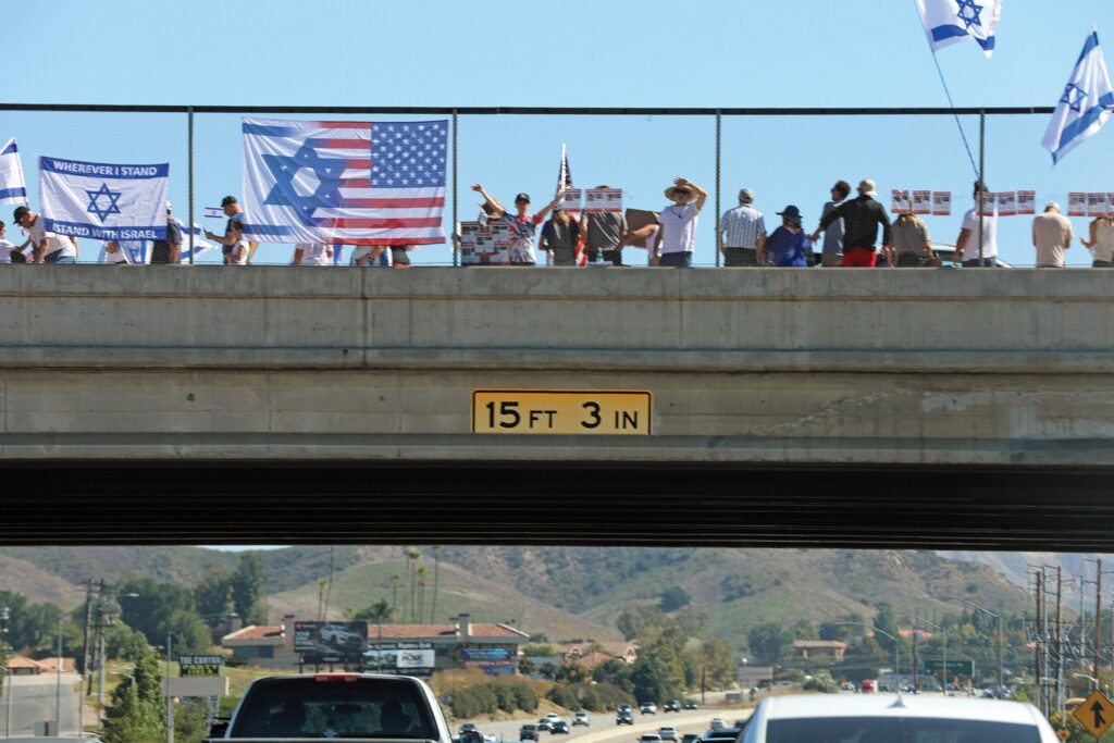 OUTRAGE—Above, pro-Israeli demonstrators on the Kanan Road overpass. Left, graffiti at Deerhill Park. Photos by RICHARD GILLARD & JOHN LOESING/Acorn Newspapers