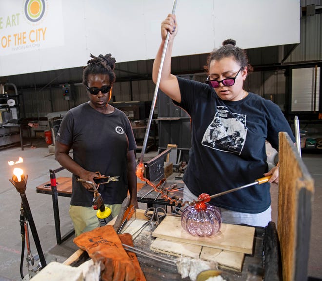 Keisha Bolton and Jessica Khalil finish one of the glass pumpkins for this weekend's 17th annual Glass & Ceramic Pumpkin Patch event at the First City Art Center.