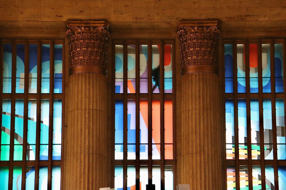 A close-up of two columns and colored panels behind them.