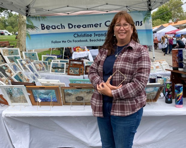 Christine Svanda showcases her beach-themed resin art, featuring sand, shells,...