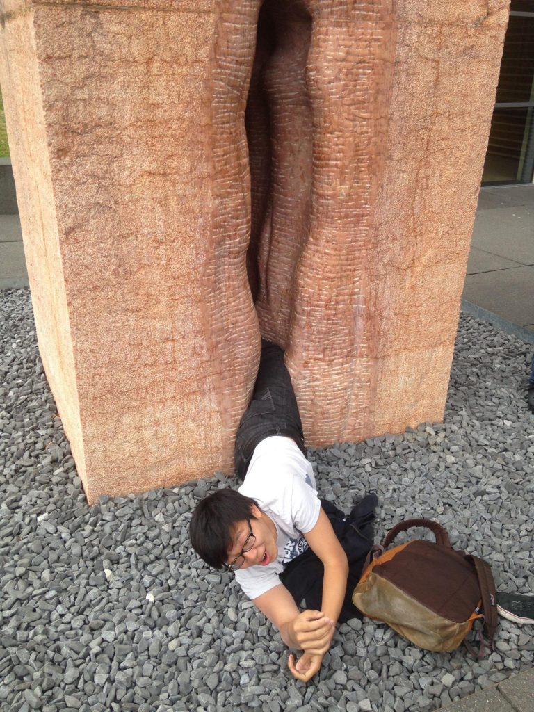 An American student waiting for firefighters to free him from Fernando de la Jara's marble vagina sculpture, Chacán-Pi (Making Love), at Germany's Tübingen University. Photo by Erick Guzman, via Imgur.