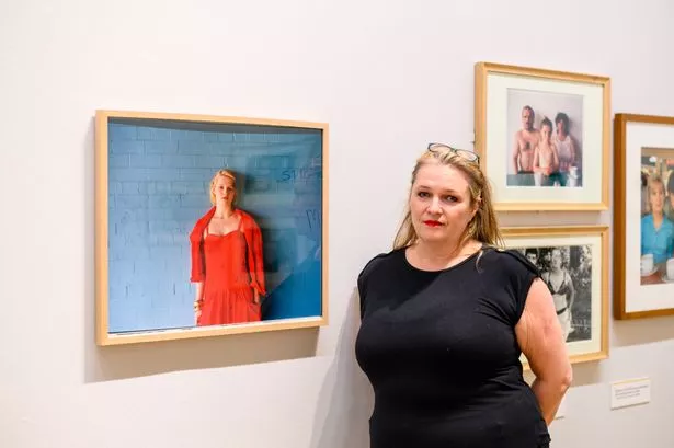 Rachel Crawford at the Photie Man exhibition in Liverpool's Walker Art Gallery alongside a Tom Wood photograph taken of her as a teenager