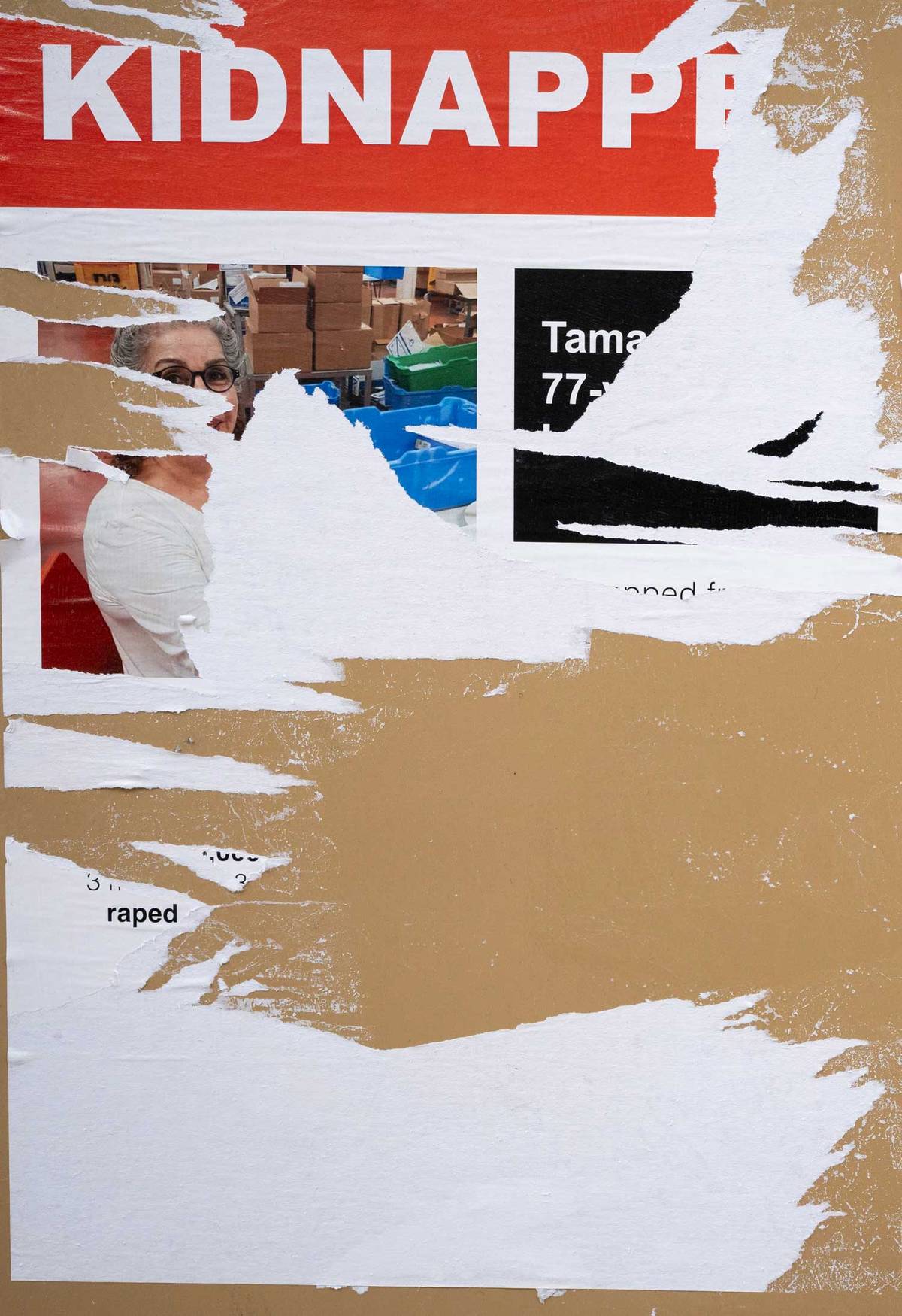 Defaced posters on a phone box window in London, November 2023
