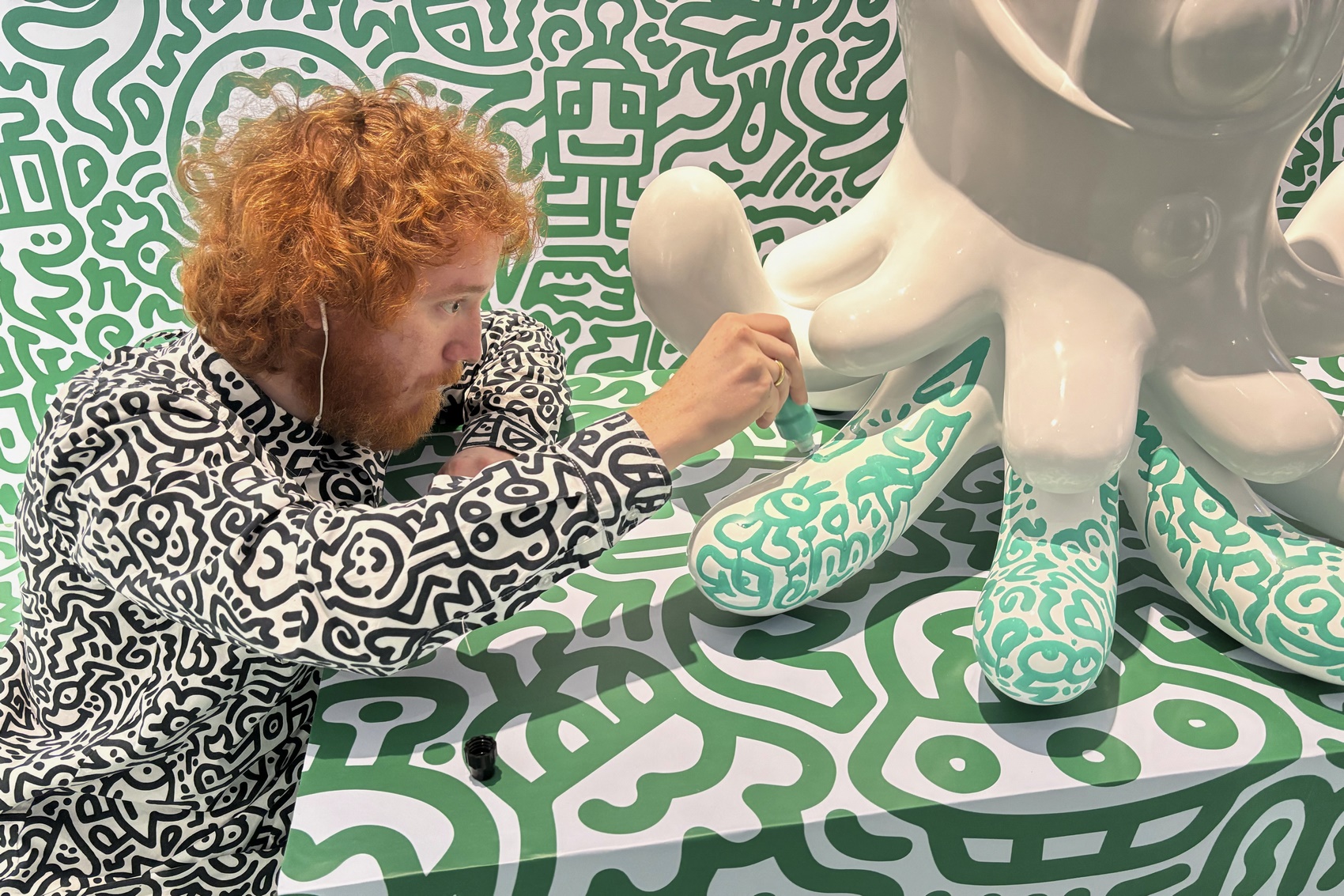 British artist Sam Cox, better known as Mr. Doodle, posing for a picture with his piece