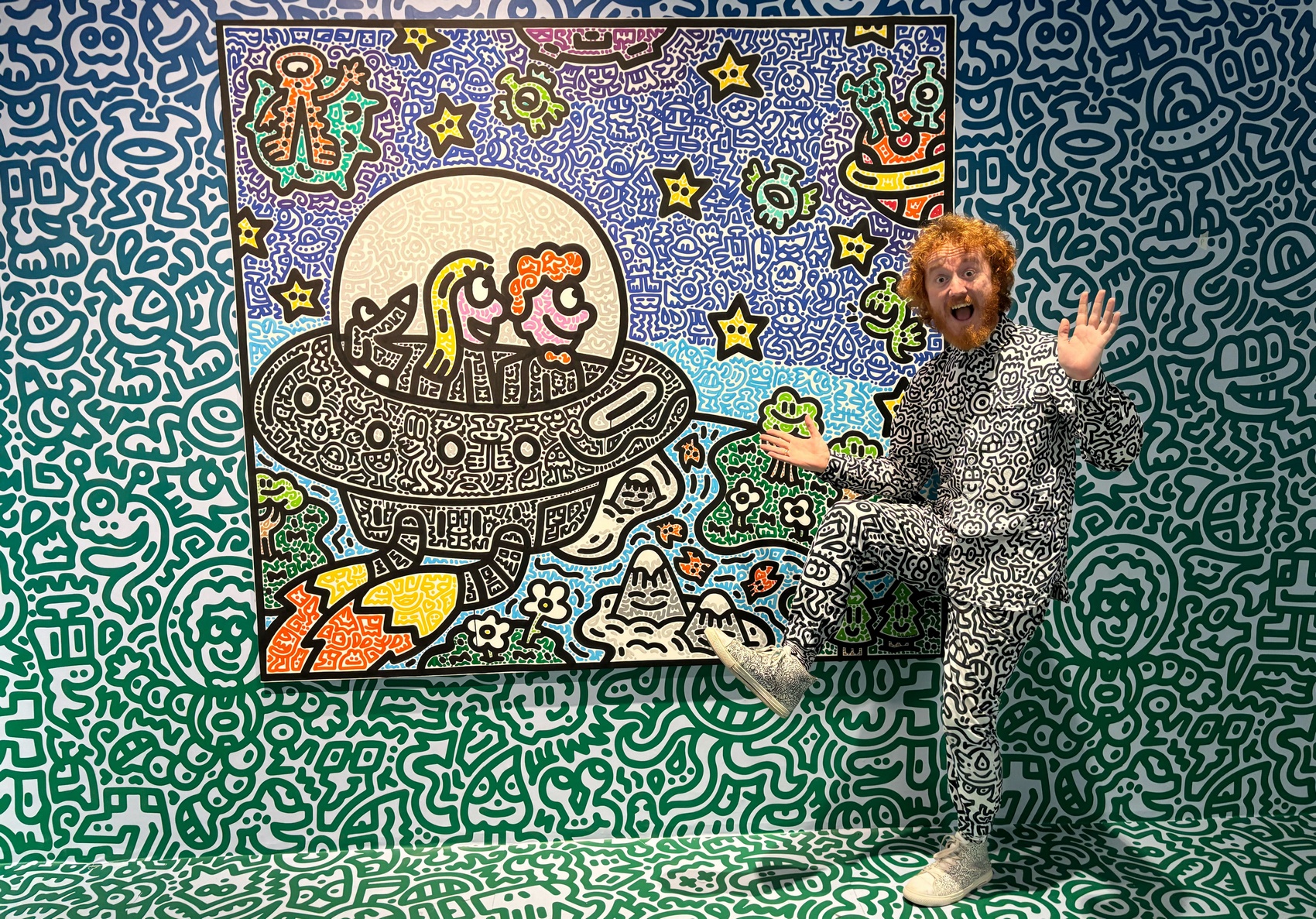 British artist Sam Cox, better known as Mr. Doodle, posing for a picture with his piece