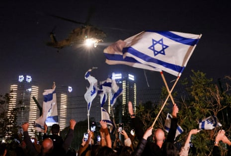 People wave Israeli flags as helicopter carrying hostages released as part of a deal between Israel and Hamas arrives at Schneider Children’s Medical Center in Petah Tikva, Israel.