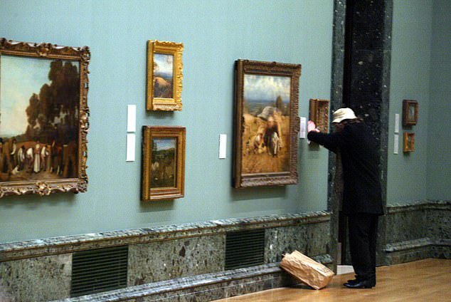 An artist believed to be Banksy putting up his latest creation at the Tate Britain in 2003