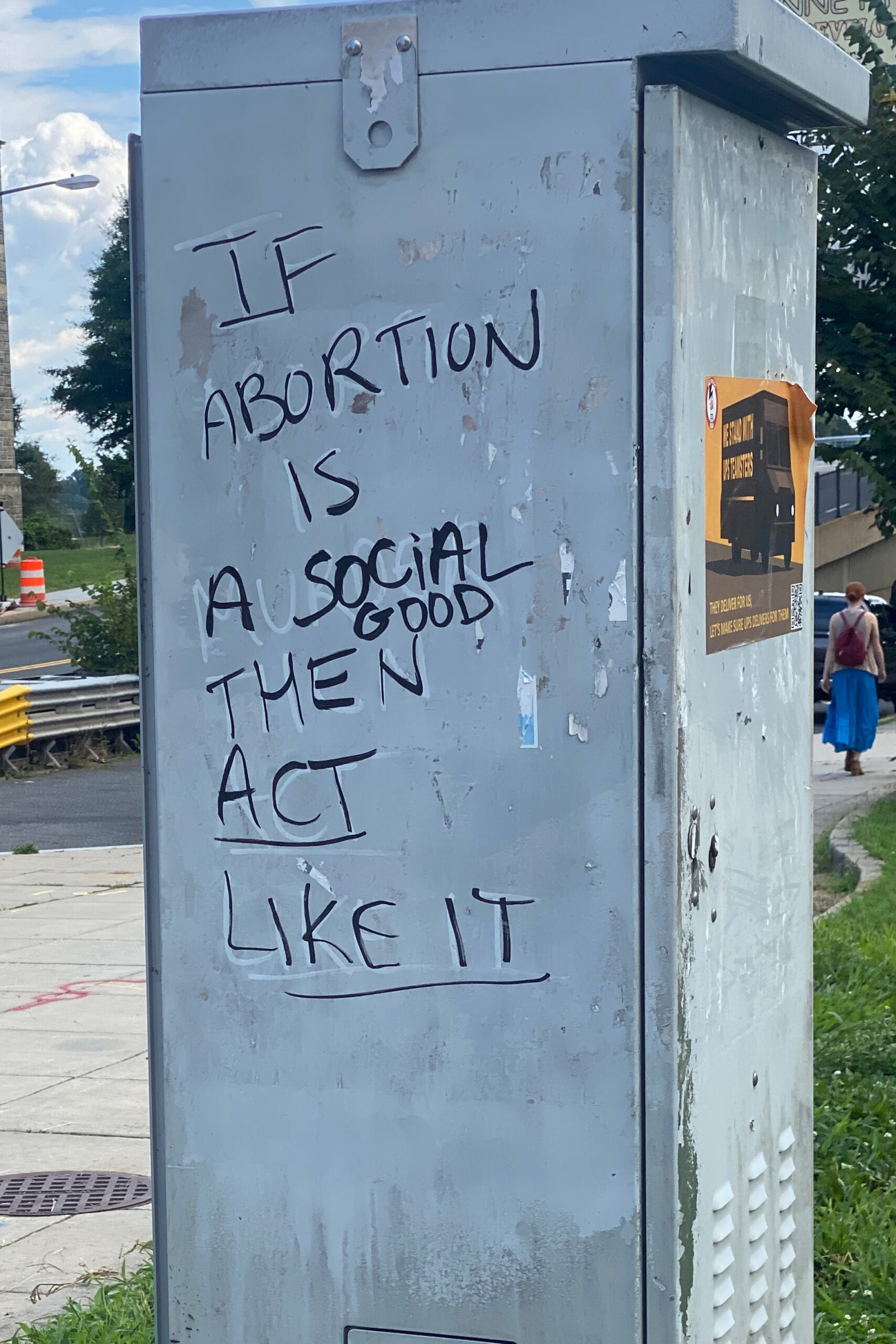 On the side of a metal pillar, graffiti is loosely written in black marker. It says, 