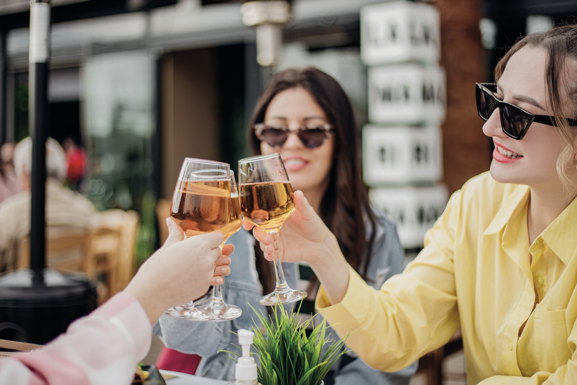 Women toast with glasses of white wine at a restaurant in Athens, Greece