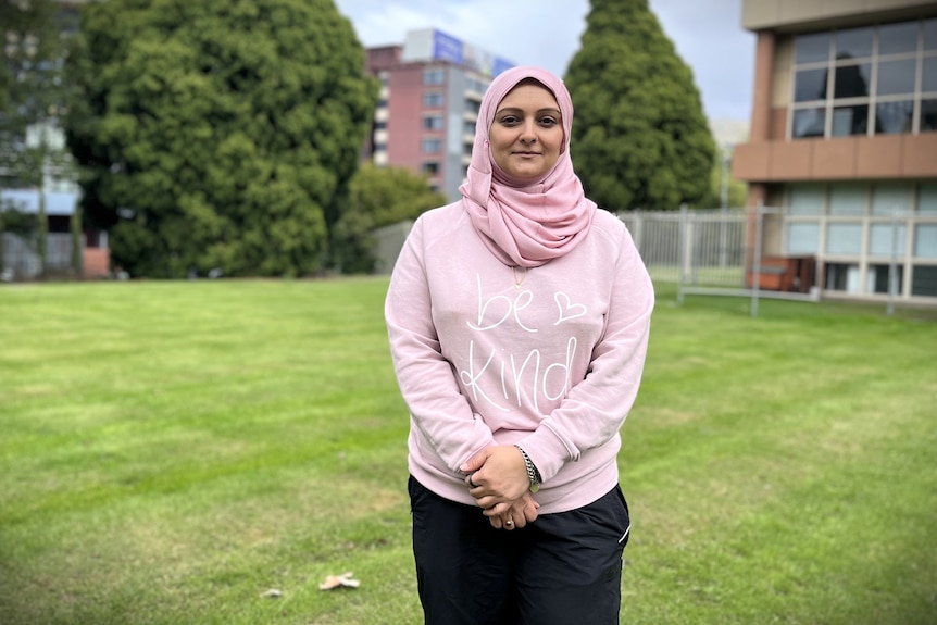 Aimen Jafri stands in a grassy area.