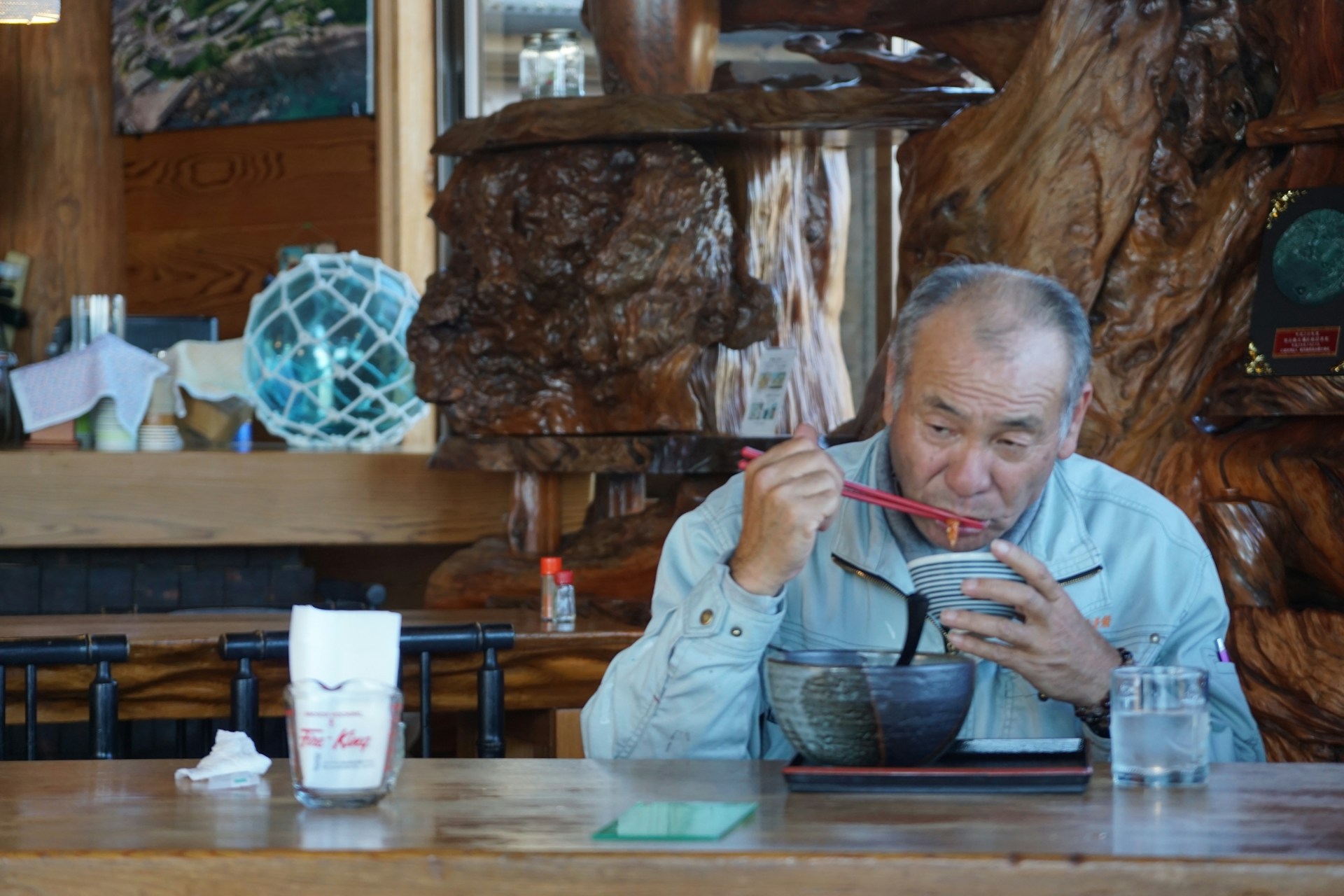 Japanese man sitting and eating A Japanese man sitting at a table alone and eating.