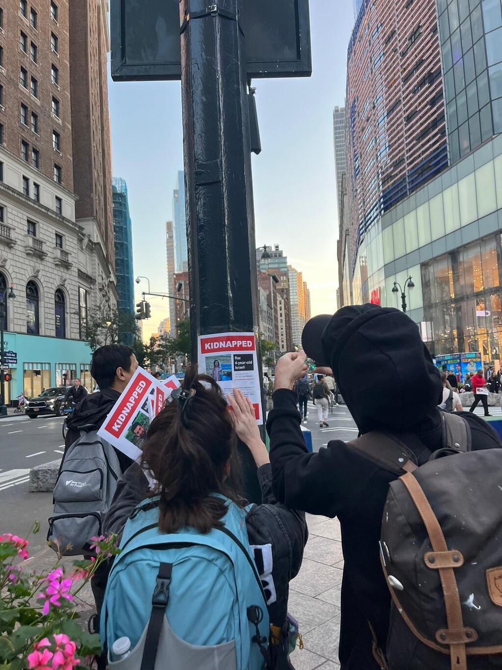 Dede and Nitzan hanging hostage posters in New York City (Photo: Mor Shani) ניצן ודדה קמפיין חטופים
