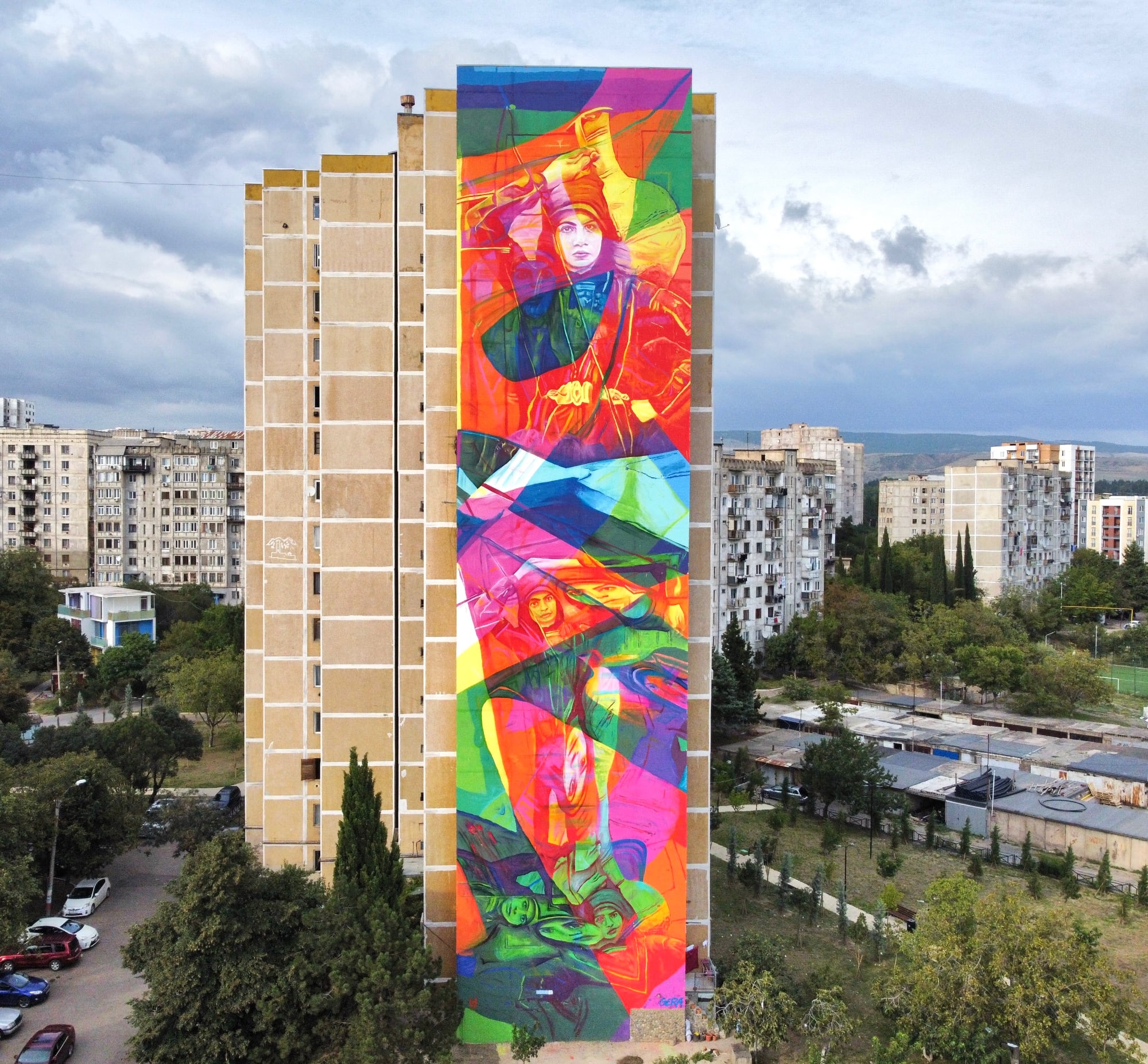 a vibrant mural with faint portraits emerging through the color