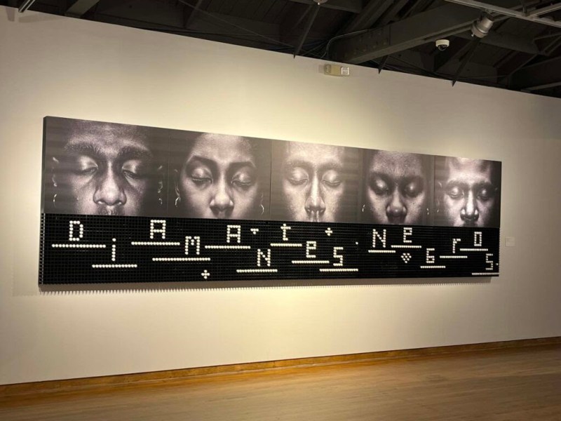 Alexandre Arrechea, large photographic installation of Black people whose mouths are covered and invisible, essentially rendering them mute
