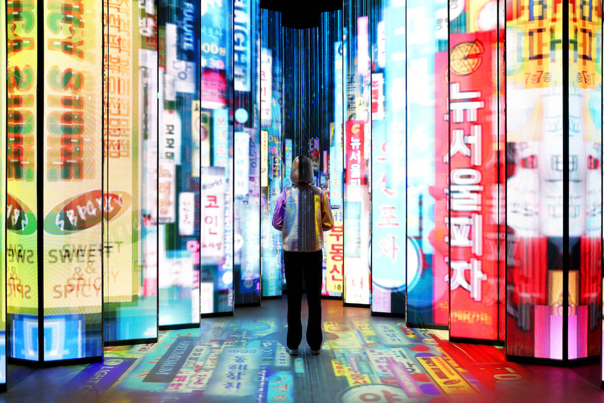 a woman standing in fron of a light installation at the <yoastmark class=