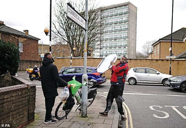 People remove a piece of art work by Banksy