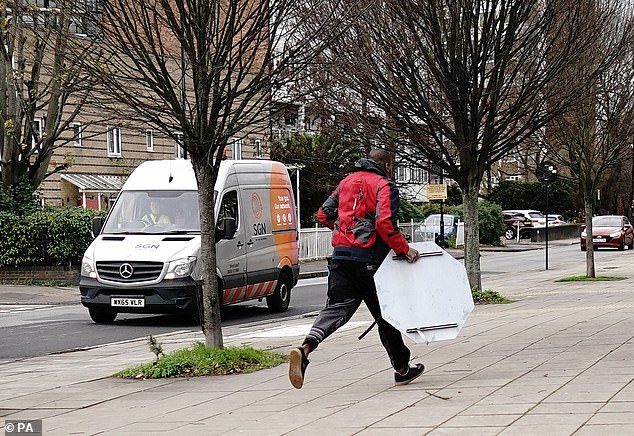The man runs away holding the sign. MailOnline has contacted the Met for comment