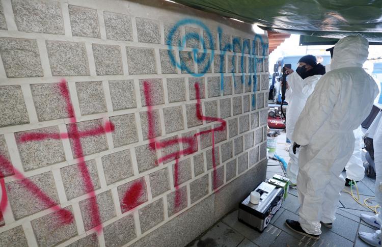 Officials from the Cultural Heritage Administration erase graffiti from the outer wall of Gyeongbok Palace in central Seoul, Sunday, a day after the initial act of vandalism took place. Yonhap