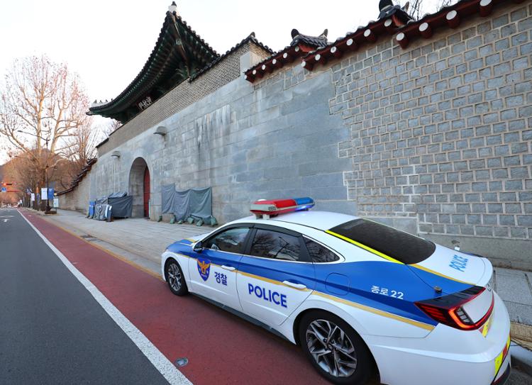 A patrol car is parked next to central Seoul's Gyeongbok Palace where more graffiti is covered up with tarps, Monday. Yonhap