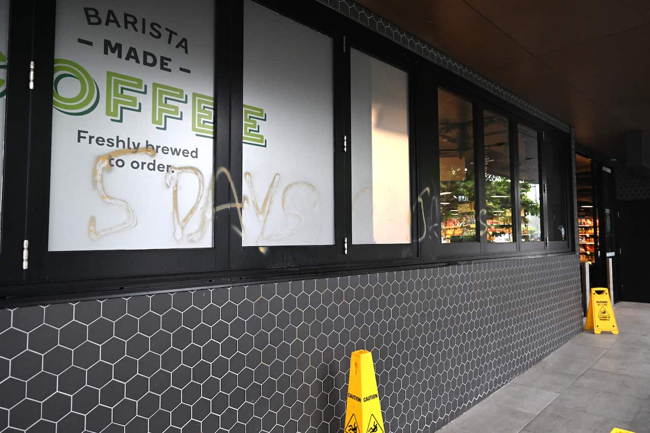The outside of a Woolworths store with graffiti on it.