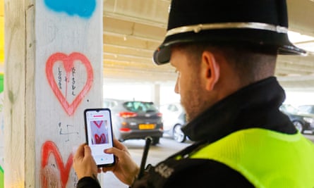 Sgt Daniel Parry photographs swastika graffiti on a car park pillar.