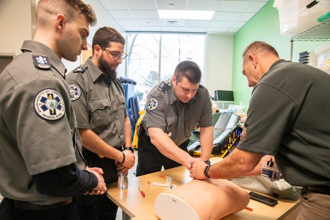 Paramedic instructor Scott Gobar (right) watches as paramedic student Colin Campbell uses a needle to relieve lung pressure during class at the newly-opened Center for Health Sciences at MassBay Community College on Franklin Street in Framingham, Jan. 30, 2024. From left are students Jacob Opela and Ibrahim Sarrar.