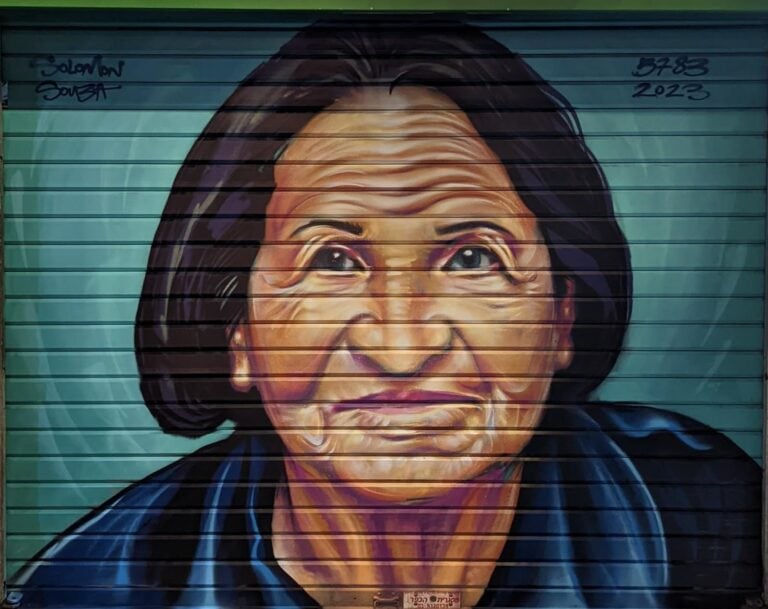 A woman in blue is one of the portraits in Machane Yehuda. Photo by Solomon Souza