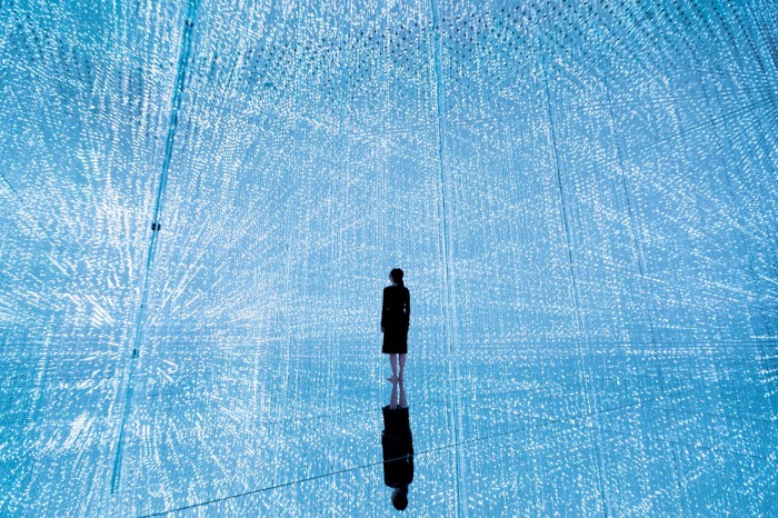 A visitor stands in a vast blue space