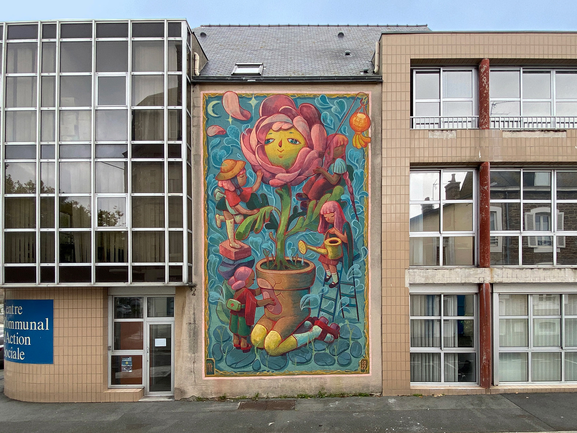 A mural on the facade of a community center showing a flower being tended to.