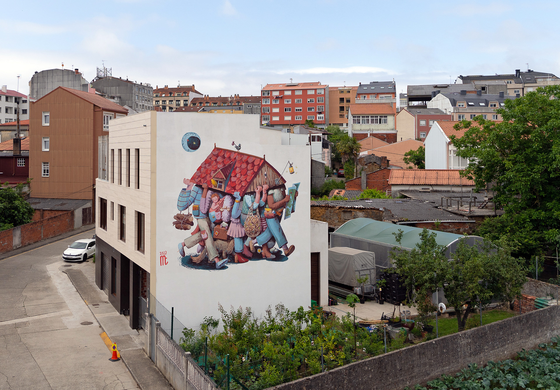 An overview of a neighborhood in Carballo, Spain, where Marija Tiurina painted a mural portraying people carrying a house roof.