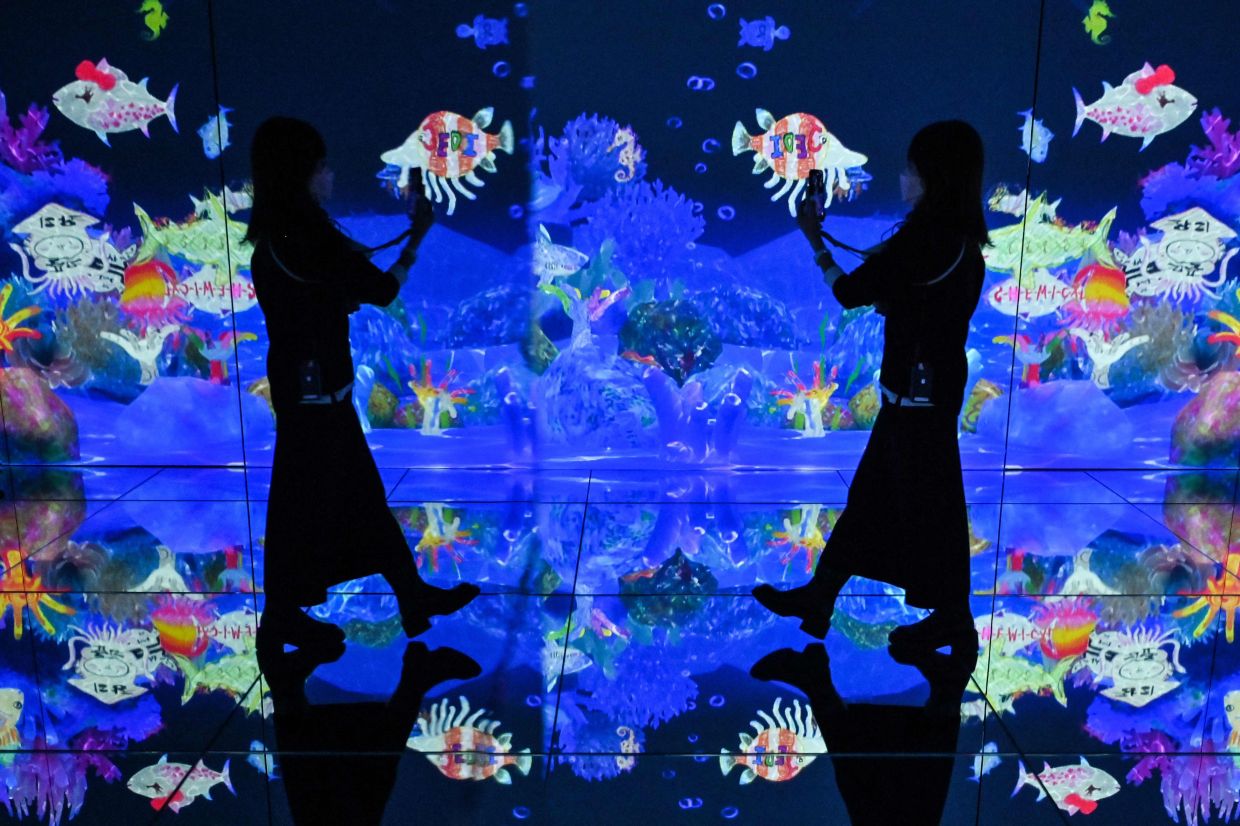 Some displays move from room to room, and others react to visitors' movements, with petals scattering as they approach and fluid lights rippling at their feet. Photo: AFP 