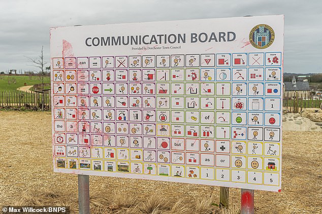 More red graffiti that has been partially removed on the front of the communications board