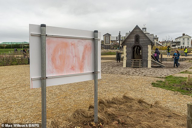 Red graffiti pictured on the back of the communication board in Great Field playground