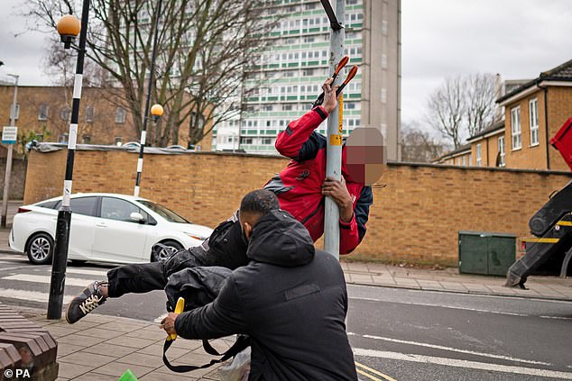 During the incident one of the men fell down while attempting to climb up the pole to the sign