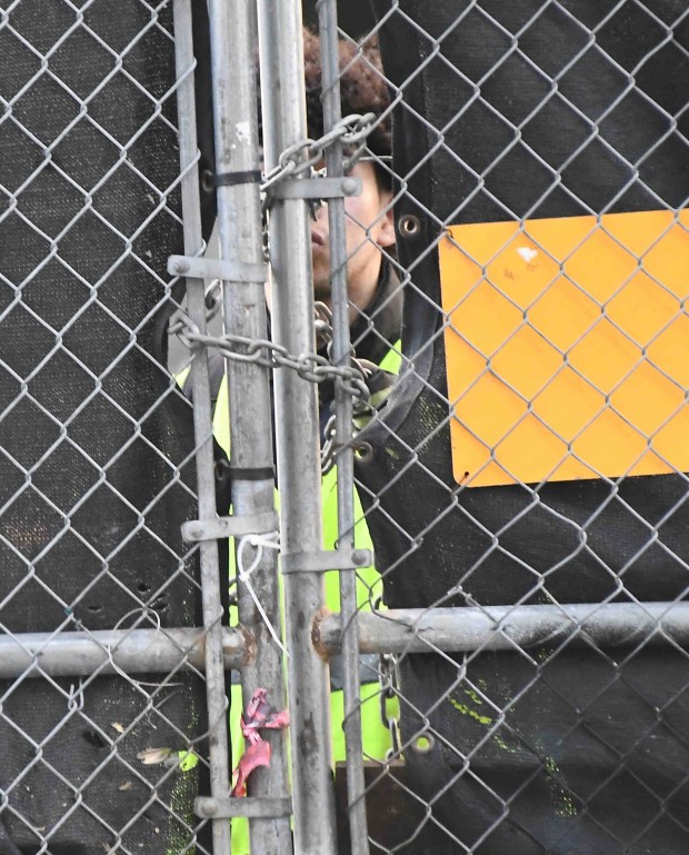 A security guard locks the gates outside one of the...