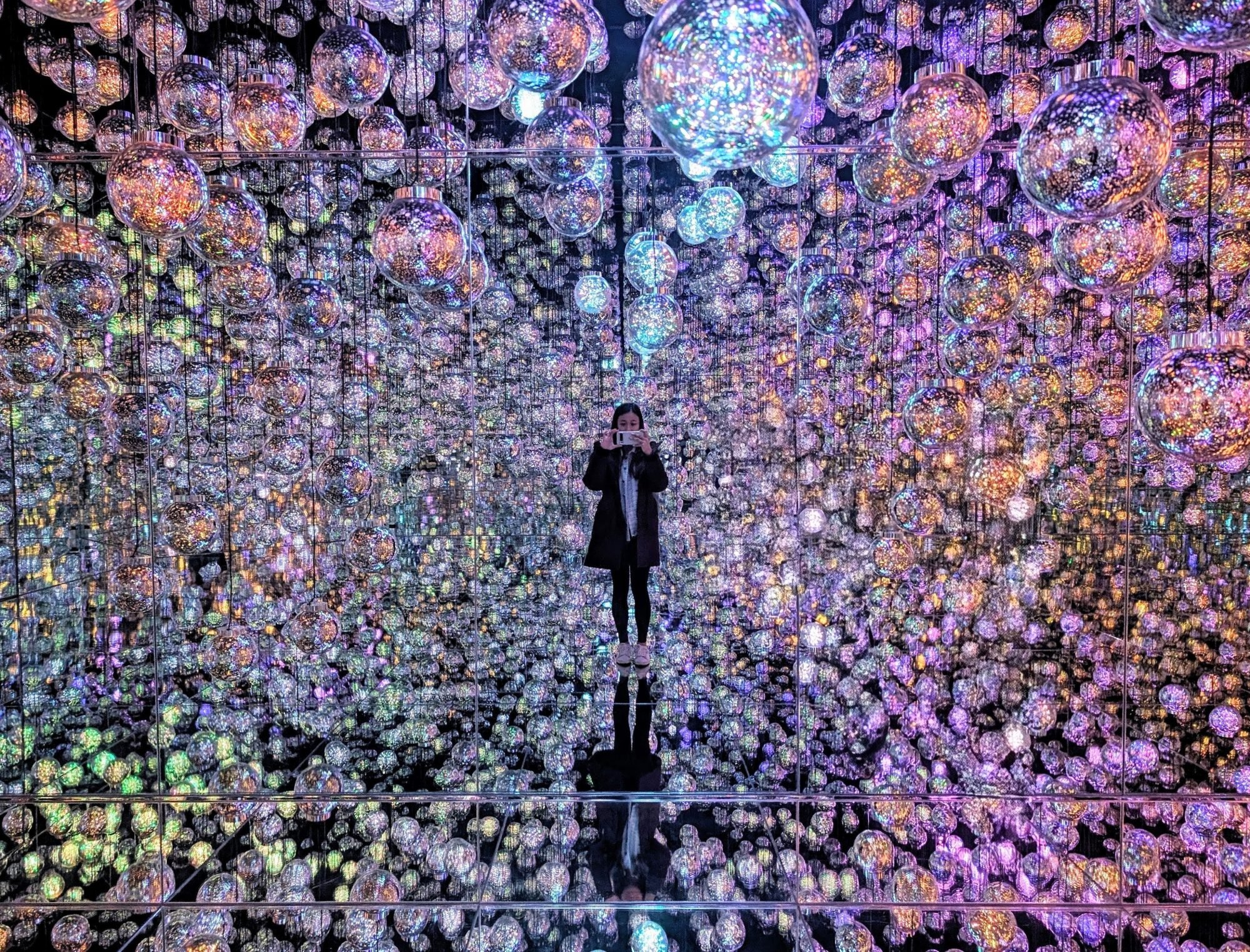 Writer Tammy Kwan stands inside “Bubble Universe: Physical Light, Bubbles of Light, Wobbling Light and Environmental Light – One Stroke” at the new teamLab Borderless in Tokyo. Photo: Tammy Kwan