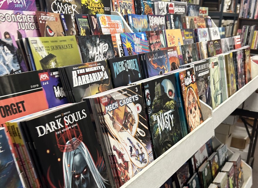A display of comic books on a rack fo shelves. 