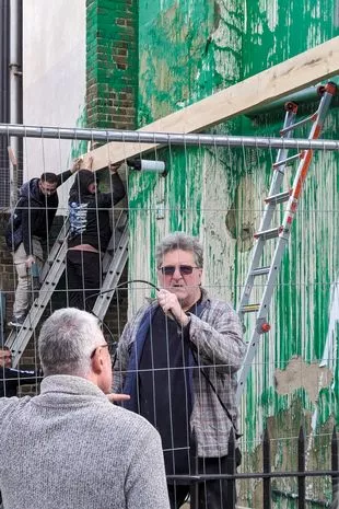 The snap shows the mysterious individivual talking to passers-by at the site of the mural in Finsbury Park